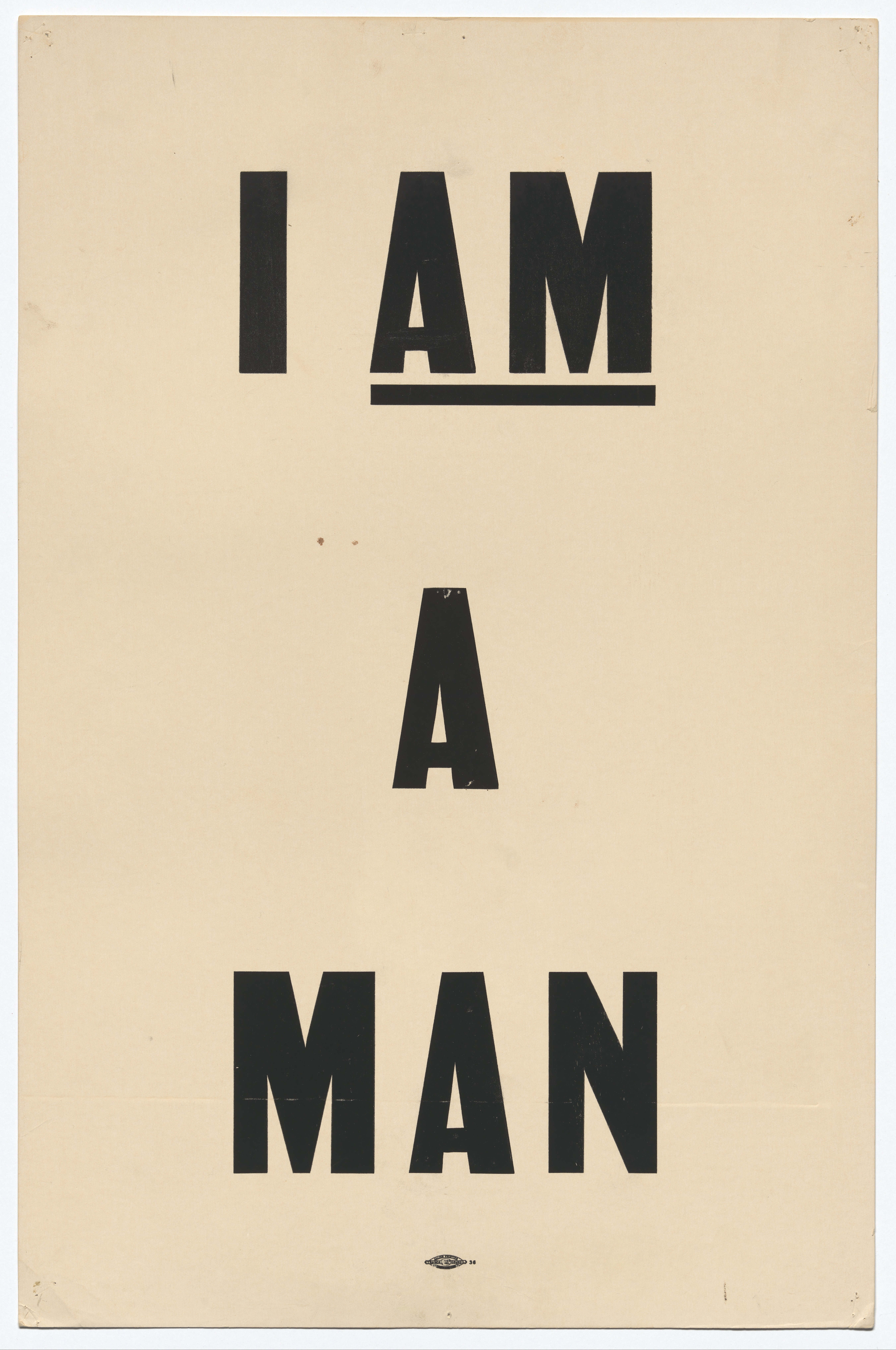 A white poster with black lettering that reads "I AM A MAN."